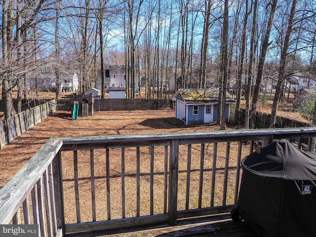 view of yard with a storage shed, a residential view, an outbuilding, fence, and a deck