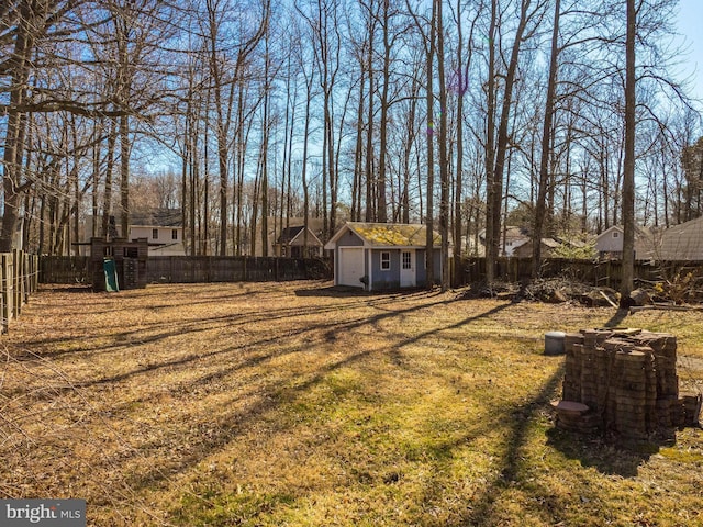 view of yard featuring a storage shed, a fenced backyard, a playground, and an outdoor structure