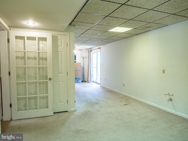 unfurnished room with light carpet, baseboards, and a drop ceiling