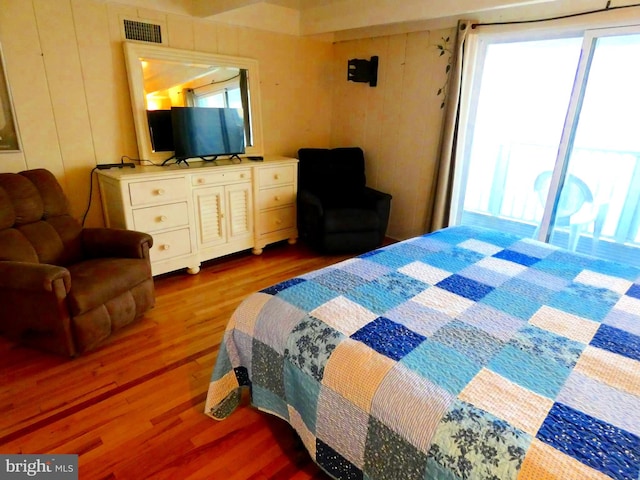 bedroom with hardwood / wood-style flooring and multiple windows