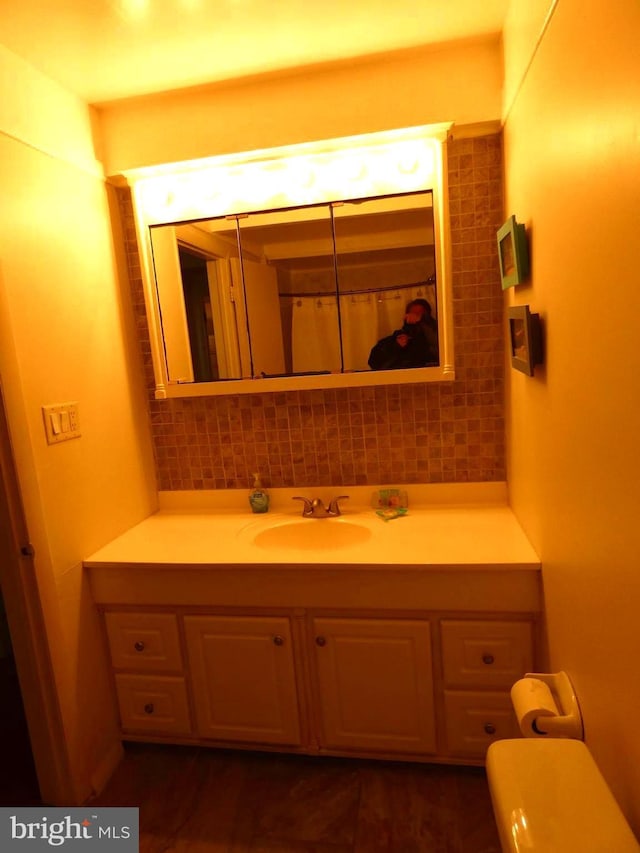 bathroom featuring vanity and backsplash