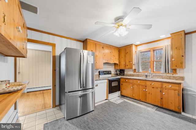 kitchen featuring sink, light tile patterned flooring, range with electric stovetop, baseboard heating, and stainless steel fridge