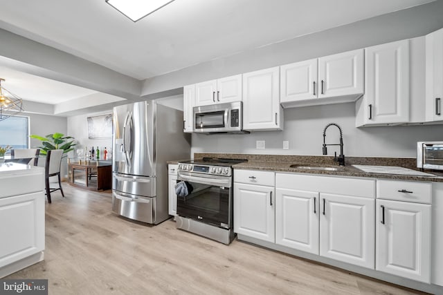 kitchen featuring stainless steel appliances, white cabinets, and a sink