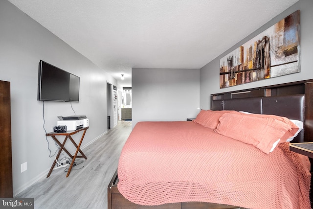 bedroom with light wood-style flooring and baseboards