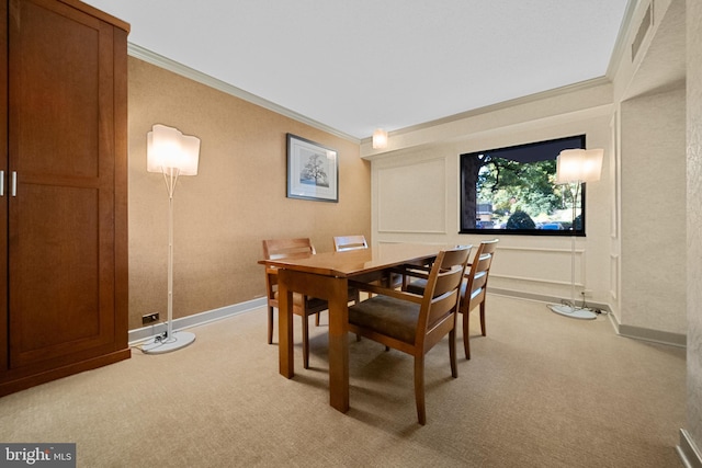 dining room featuring ornamental molding, light carpet, and baseboards