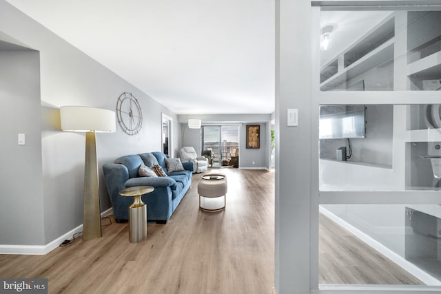 living area with light wood-style flooring and baseboards