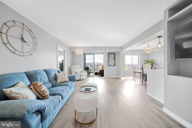 living room with baseboards, wood finished floors, and a wall mounted air conditioner