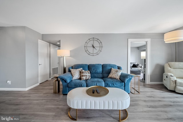 living room featuring baseboards, visible vents, and light wood-style floors