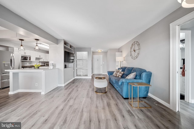 living area with light wood-type flooring and baseboards