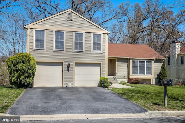 tri-level home with an attached garage, aphalt driveway, and a front yard