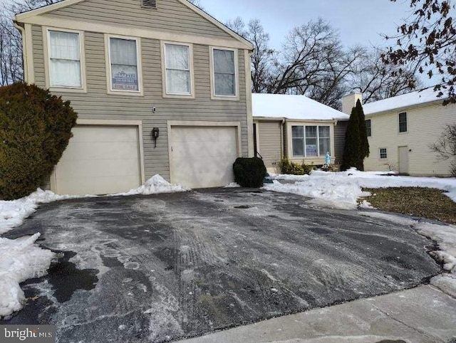 exterior space with a garage and aphalt driveway