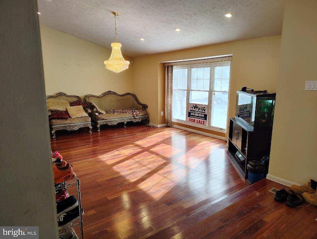 living area featuring recessed lighting, baseboards, a textured ceiling, and hardwood / wood-style floors