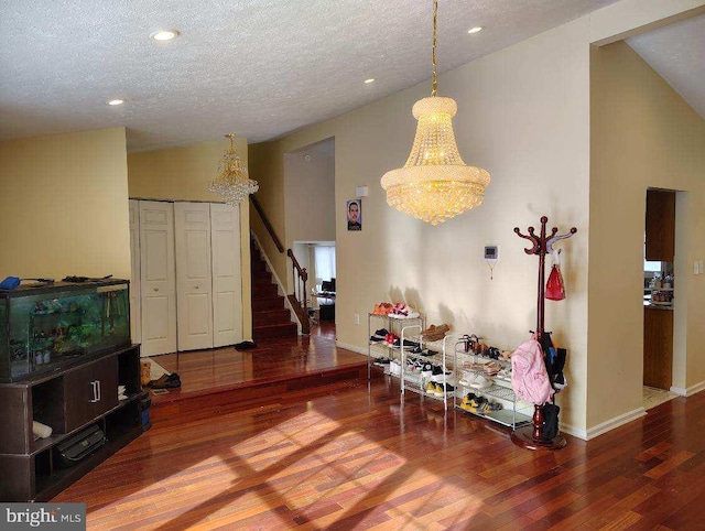 dining space with lofted ceiling, stairway, a textured ceiling, wood finished floors, and baseboards