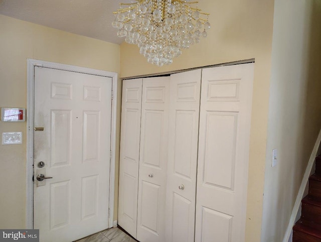 foyer entrance with a chandelier and stairway