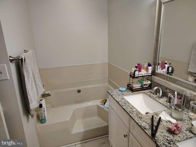 bathroom with a garden tub and vanity