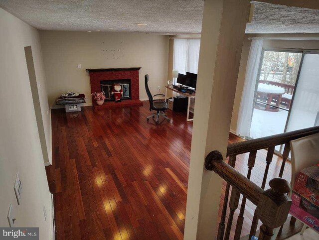 hall featuring a textured ceiling, stairway, and hardwood / wood-style floors