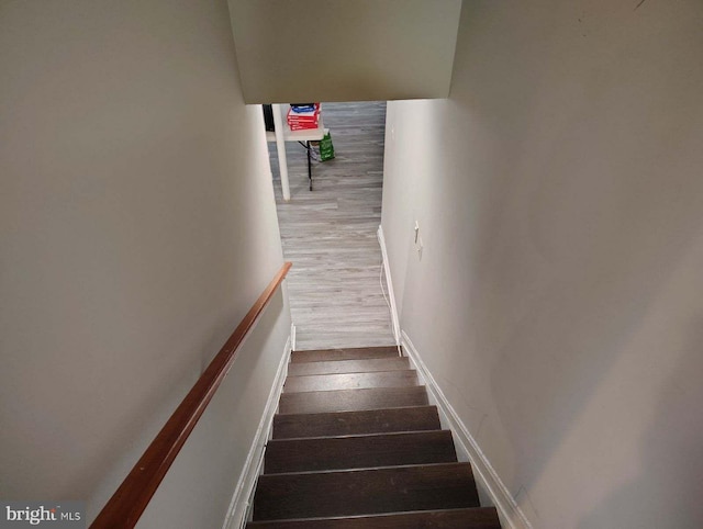 stairway featuring baseboards and wood finished floors