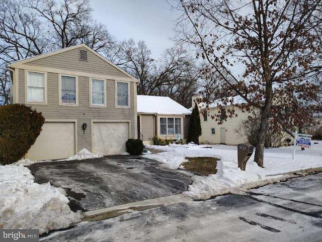 view of front of property with aphalt driveway and a garage