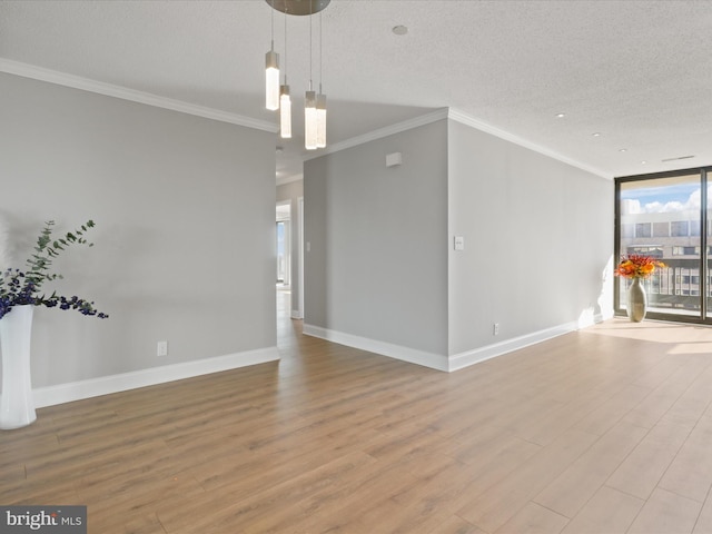 unfurnished living room with floor to ceiling windows, a notable chandelier, a textured ceiling, and ornamental molding