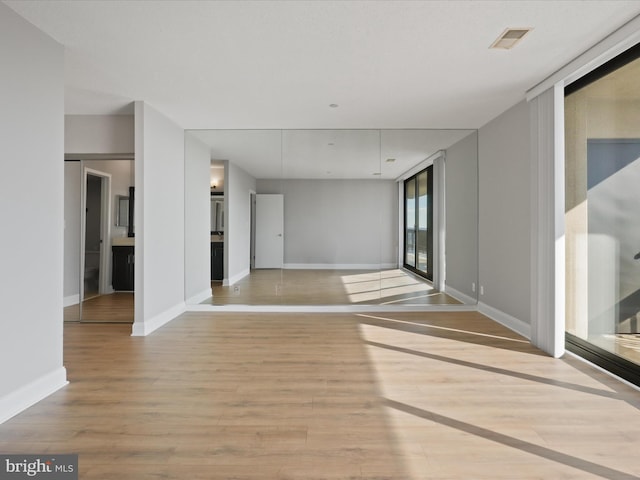 spare room with light wood-type flooring and a wall of windows