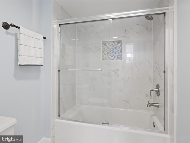 bathroom with shower / bath combination with glass door and toilet