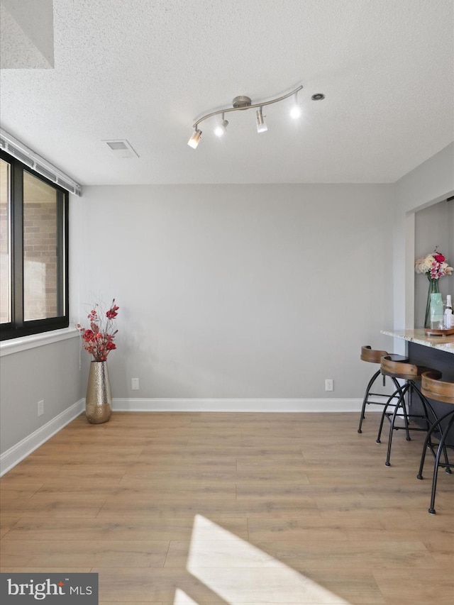 dining room with light hardwood / wood-style floors and a textured ceiling