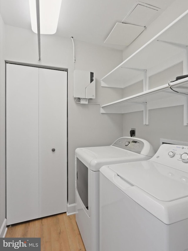 laundry room featuring washer and dryer and light hardwood / wood-style flooring