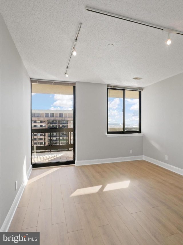 spare room featuring a textured ceiling and rail lighting