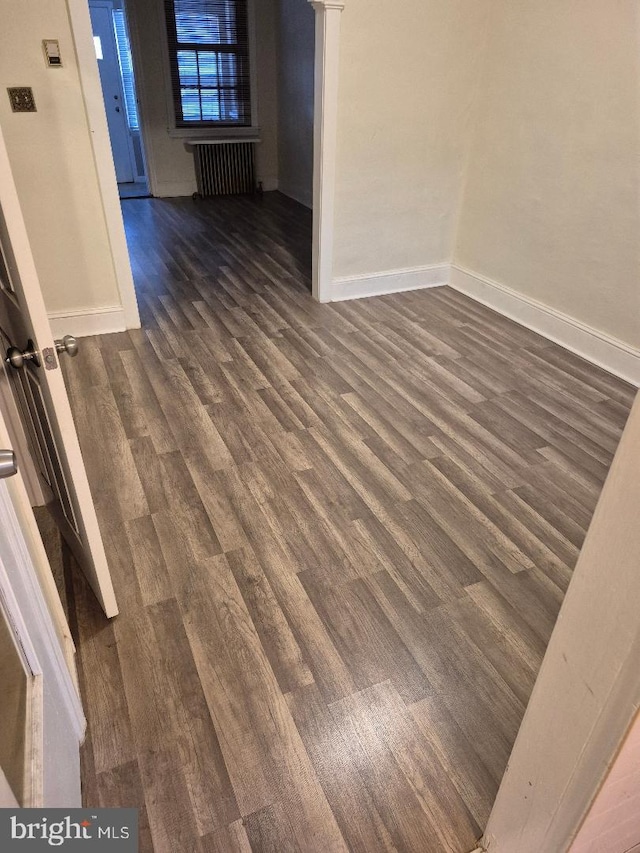 unfurnished room with dark hardwood / wood-style floors and radiator