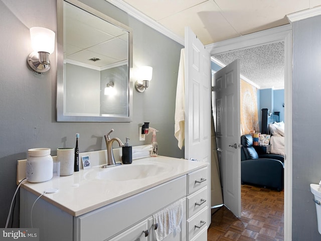 bathroom with vanity, toilet, parquet floors, and crown molding