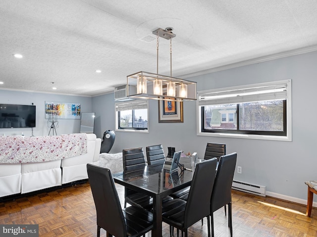 dining room featuring ornamental molding, parquet flooring, a textured ceiling, and a baseboard heating unit