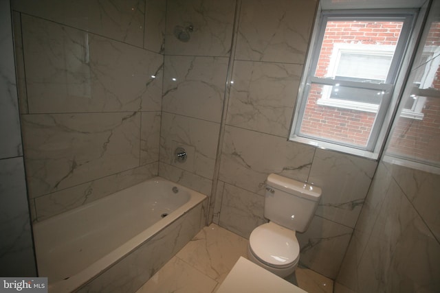 bathroom featuring tiled shower / bath combo and toilet