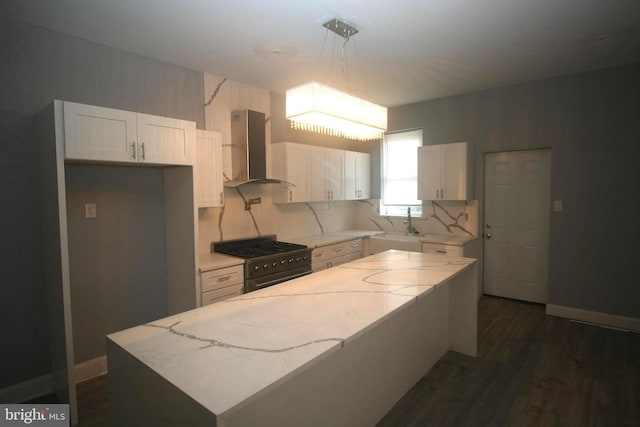 kitchen with white cabinets, wall chimney exhaust hood, light stone counters, and high end black range