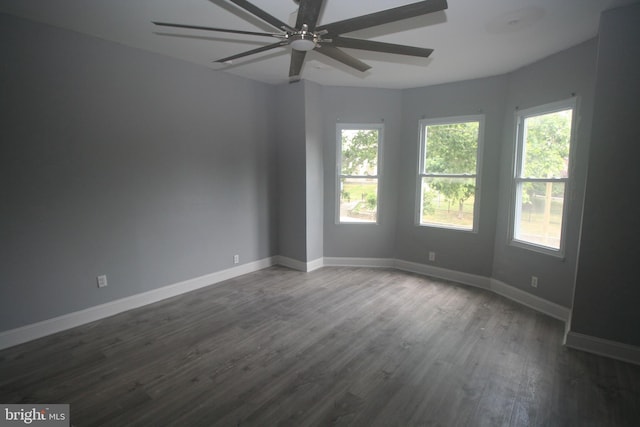 empty room with ceiling fan and dark hardwood / wood-style flooring