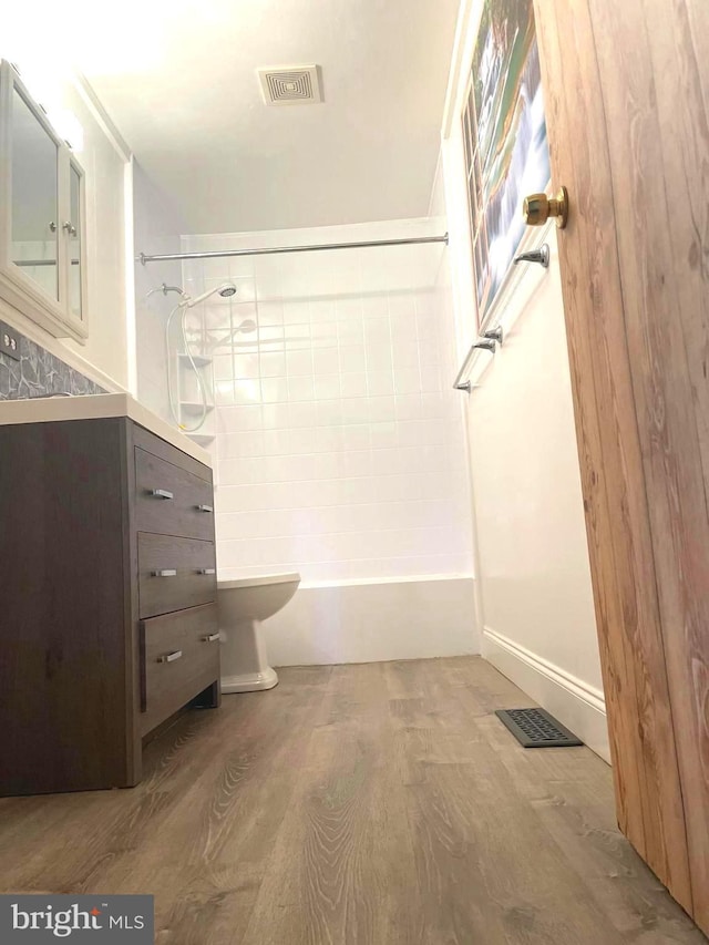 full bathroom featuring shower / bathing tub combination, hardwood / wood-style floors, vanity, and toilet