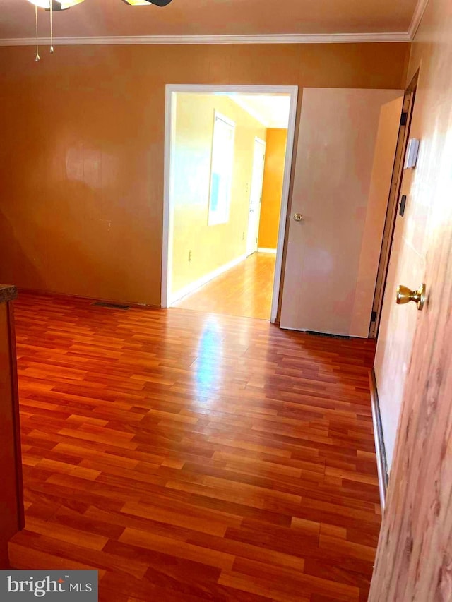 empty room featuring crown molding and hardwood / wood-style flooring