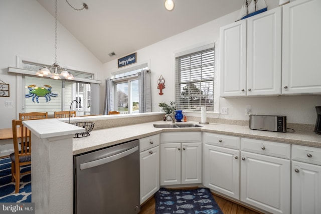 kitchen featuring stainless steel dishwasher, kitchen peninsula, white cabinetry, and hanging light fixtures