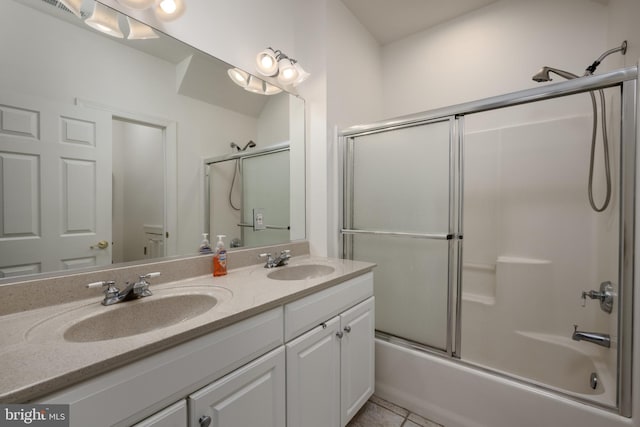 bathroom with tile patterned floors, vanity, and bath / shower combo with glass door