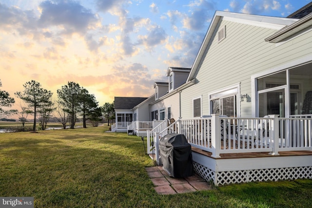 yard at dusk featuring a wooden deck