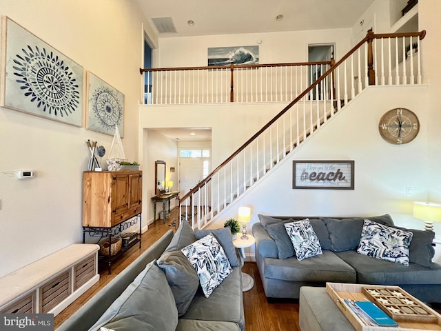 living room featuring wood-type flooring and a high ceiling