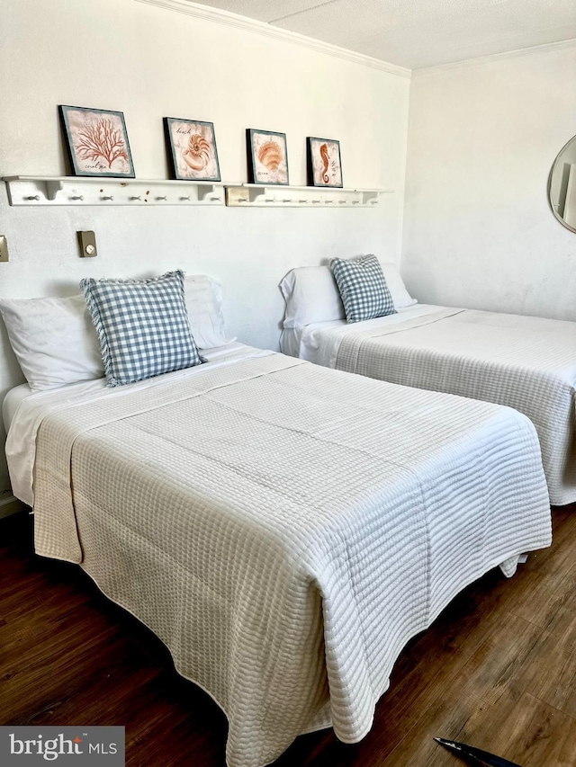 bedroom with dark wood-type flooring and crown molding