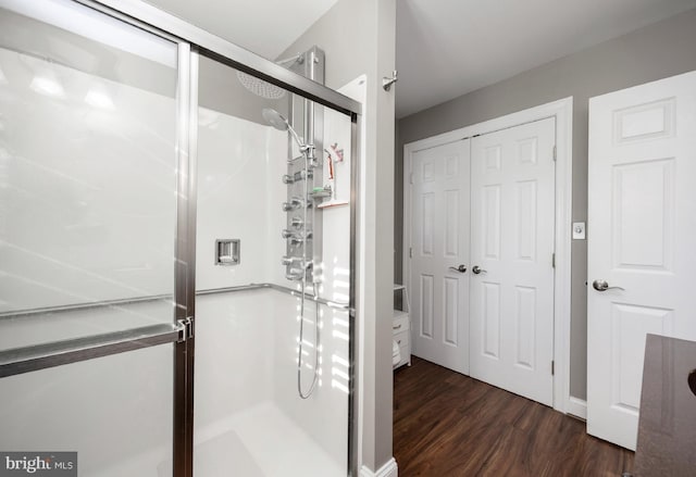 bathroom with an enclosed shower and wood-type flooring