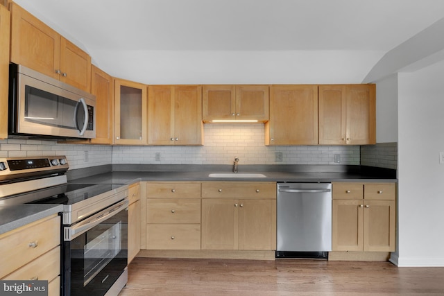 kitchen with appliances with stainless steel finishes, backsplash, light brown cabinetry, and sink