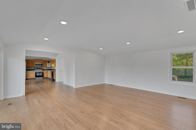 unfurnished living room with light wood-type flooring and vaulted ceiling