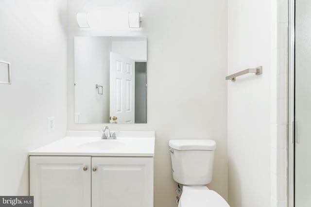 bathroom with vanity, toilet, and a shower with shower door