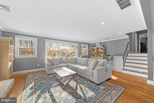 living room featuring ornamental molding and light wood-type flooring