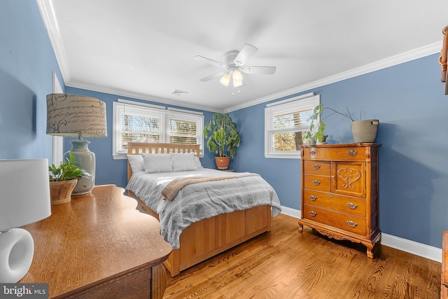 bedroom featuring wood-type flooring, ornamental molding, and ceiling fan