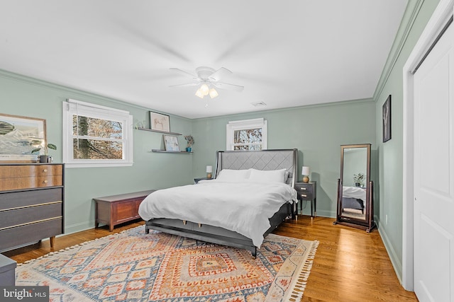 bedroom with ceiling fan, ornamental molding, hardwood / wood-style floors, and a closet