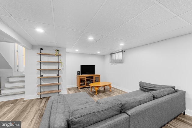 living room featuring a drop ceiling and hardwood / wood-style flooring