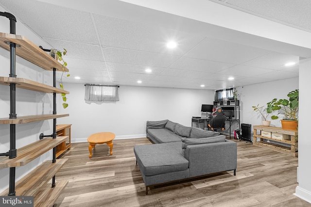 living room featuring hardwood / wood-style flooring and a paneled ceiling